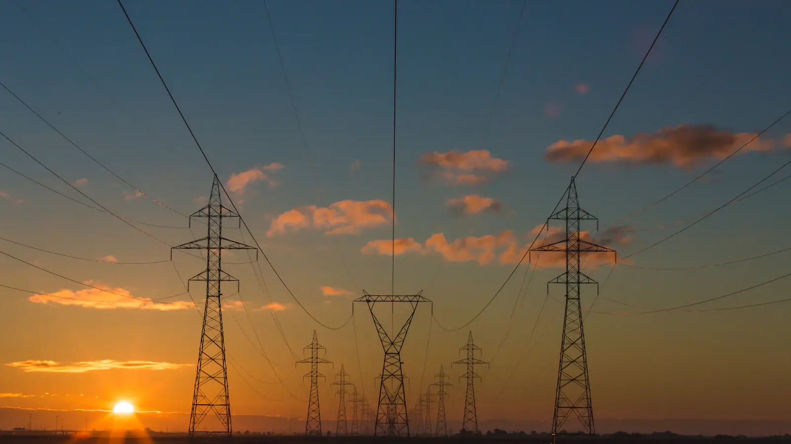 Hochspannungsmasten einer Stromtrasse in der Morgendämmerung
